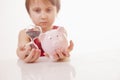 Concept: time is money. Humorous portrait of cute little business child girl holding a sand clock and piggy bank. Selective focus Royalty Free Stock Photo