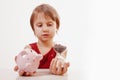 Concept: time is money. Humorous portrait of cute little business child girl holding a sand clock and piggy bank. Space for text Royalty Free Stock Photo