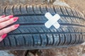 Concept: tire repair. The woman made the patch on the wheel of a car of bactericidal adhesive plaster.