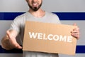 The concept of tolerance for immigrants and people of different life positions. A man holds a cardboard and stretches out his hand