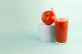 The concept of tomato juice consumption. Tomato juice and juicy tomato on a blue background Royalty Free Stock Photo
