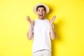 Concept of tourism and summer. Happy young man in straw hat looking amazed, reacting to surprise, standing over yellow Royalty Free Stock Photo