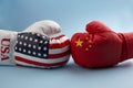 Concept of trade war between USA and China. Two hands of wearing boxing gloves with China and USA flag. Royalty Free Stock Photo