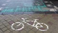 Concept traffic sign. White bike lane sign on wet sidewalk. Bicycle markings. Royalty Free Stock Photo