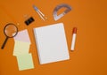 The concept of training and education. Three empty square notes, an empty checkered notebook, and office supplies on an orange Royalty Free Stock Photo