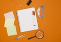 The concept of training and education. Three empty square notes, an empty checkered notebook, and office supplies on an orange Royalty Free Stock Photo