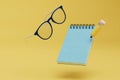 the concept of training or work. notebook with a pencil and glasses on a yellow background. 3d render