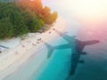 The concept of travel and air travel. Top view of the ocean coast, with the shadow on the water from the plane taking off. Light. Royalty Free Stock Photo