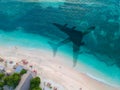 The concept of travel and air travel. Top view of the ocean coast, with the shadow on the water from the plane taking off Royalty Free Stock Photo