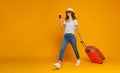 Concept of travel. happy woman girl with suitcase and passport on yellow background