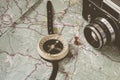 The concept of travel. The retro camera and the compass are on top of the old map. Tourist routes and trails are marked on a Royalty Free Stock Photo