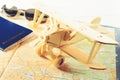 Concept of travelling, shopping, vacation, rest and relax. Selective focus on wooden airplane, on the background sunglasses, pass