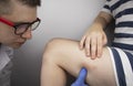 The vascular surgeon examines the outer thigh where the varicose veins are present. Preparation for laser treatment and