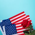 Concept of Independence day or Memorial day. American Flag over blue table background with red rose Royalty Free Stock Photo