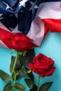 Concept of Independence day or Memorial day. American Flag over blue table background with red rose Royalty Free Stock Photo