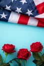 Concept of Independence day or Memorial day. American Flag over blue table background with red rose Royalty Free Stock Photo