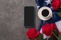 Concept of Independence day or Memorial day with smart phone and coffee. Flag over dark gray table background