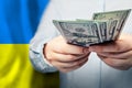 Concept of Ukrainian finanse, banking and saving money. US dollars cash on flag of Ukraine