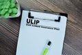 Concept of ULIP - Unit Linked Insurance Plan write on paperwork on a book isolated on Wooden Table Royalty Free Stock Photo