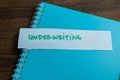 Concept of Underwriting write on sticky notes isolated on Wooden Table Royalty Free Stock Photo