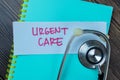 Concept of Urgent Care write on sticky notes with stethoscope isolated on Wooden Table Royalty Free Stock Photo