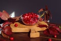 The concept of using medicinal berries in cooking. Ripe cranberries in a glass cup on a kitchen wooden board with leaves of maiden Royalty Free Stock Photo