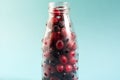 The concept of using quick-frozen products, a mixture of frozen berries in a transparent bottle