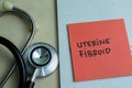 Concept of Uterine Fibroid write on sticky notes with stethoscope isolated on Wooden Table