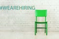 Concept of vacant chair. Green wooden chair against white brick wall. We are hiring concept Royalty Free Stock Photo