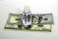 the concept of vaccination and business an ampoule with the inscription covid19 vaccine stands on banknotes on a white