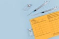 Concept for vaccination with syringe, vial and yellow international certificate of vaccination on blue background