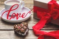 Concept Valentine`s Day. Gift box with red bow and cup of coffee on wooden table. copy space Royalty Free Stock Photo