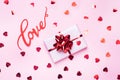 Concept Valentine`s Day. Pink background with red hearts and gift. Flat lay copy space. Greeting card and gift Royalty Free Stock Photo