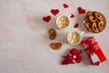 Two mugs of hot coffee with marshmallows, cookies in the form of hearts, a gift box and decorative hearts on a background of pink Royalty Free Stock Photo