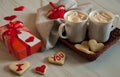 Two mugs of hot coffee with marshmallows, cookies in the form of hearts, a gift box and decorative hearts on a marble background. Royalty Free Stock Photo