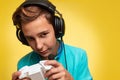 The concept of virtual and computer games. A portrait of teenage boy in a blue t-shirt and headphones, with a joystick in his Royalty Free Stock Photo