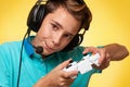 The concept of virtual and computer games. A teenage boy in a blue t-shirt and headphones, with a joystick in his hands Royalty Free Stock Photo