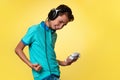 The concept of virtual and computer games. A teenage boy in a blue t-shirt and headphones, with a joystick in his hands, rejoices Royalty Free Stock Photo