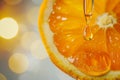 Concept Vitamin C, drop of oil, serum from pipette on orange