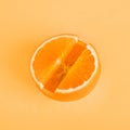 Concept Vitamin C. Fresh orange in pill form Orange background.