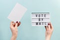 Concept of voting by mail, US elections. A woman holds a sign on a blue background Royalty Free Stock Photo