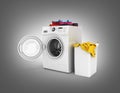 Concept of washing clothes Washing machine with colored towels and washing basket with dirty clothes isolated on black gradient