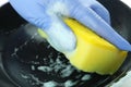 Concept of washing pan with female hand in glove and sponge Royalty Free Stock Photo