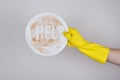 Concept of washing piles stack of dirty with left-overs cutlery. Side profile cropped close up photo of hand in protective rubber