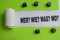 Concept of Wer? Wie? Was? Wo? Text written in torn paper Royalty Free Stock Photo