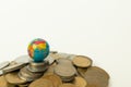 Concept of whole world stand on Money, Stack of Indian currency coins with globe above the coins on isolated background