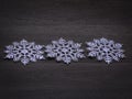 Concept of winter holidays, background of three snowflakes on a wooden surface