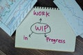 Concept of WIP - Work in Progress write on a book isolated on Wooden Table Royalty Free Stock Photo