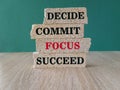 Concept word Decide Commit Focus Succeed on beautiful brick blocs. Beautiful green background, wooden table. Business decide