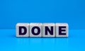 Concept word DONE on cubes on a blue background Royalty Free Stock Photo